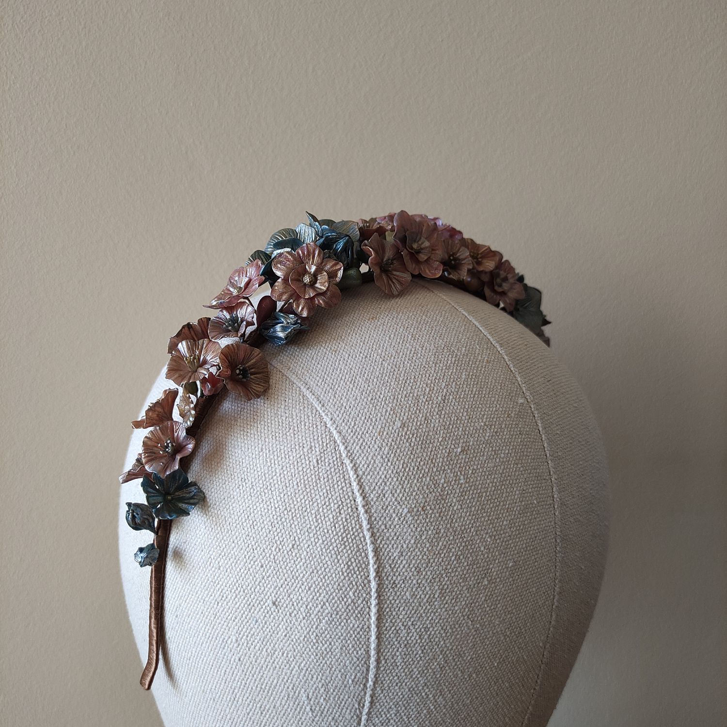 Handcrafted fantasy floral headpiece with metallic finish, featuring red and blue flowers and golden leaves.