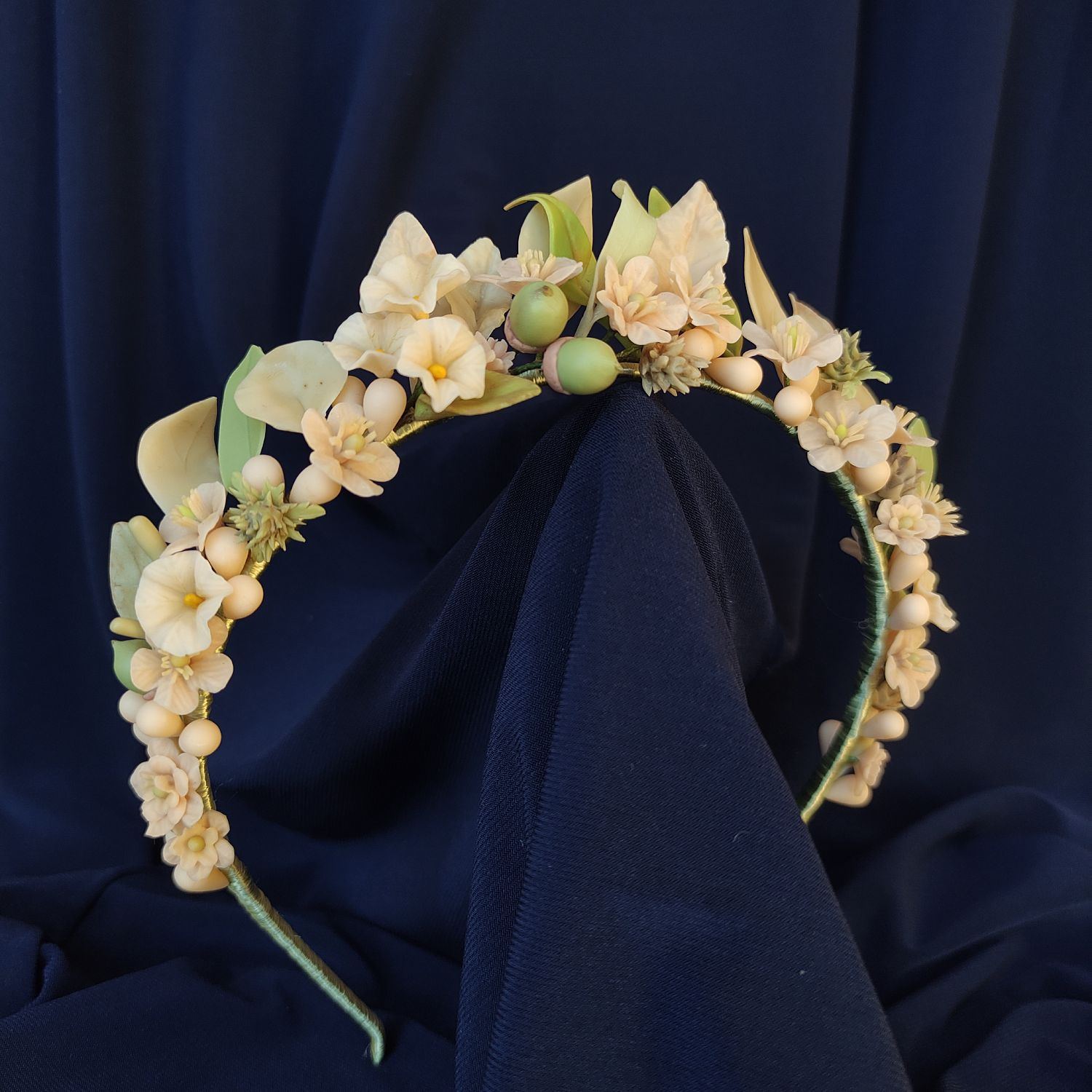 diadema dehesa Handcrafted headband inspired by the Andalusian dehesa landscape, featuring hand-modeled porcelain wildflowers, acorns, and thistles on a silk-wrapped base, perfect for bridal or communion looks.