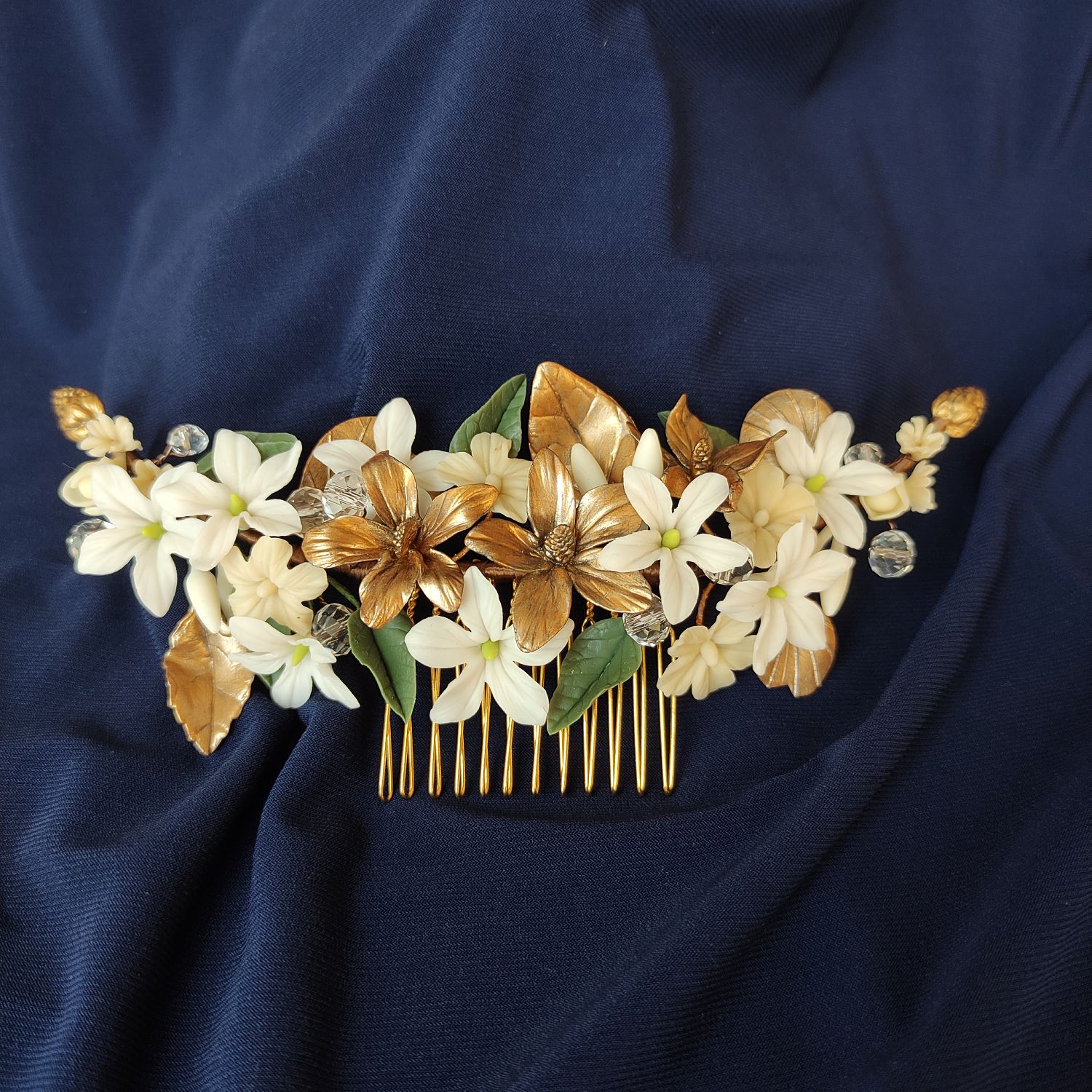 peinecillo orfir Handmade bridal hair comb with white, gold and nude porcelain flowers, green and gold leaves, and clear crystals.