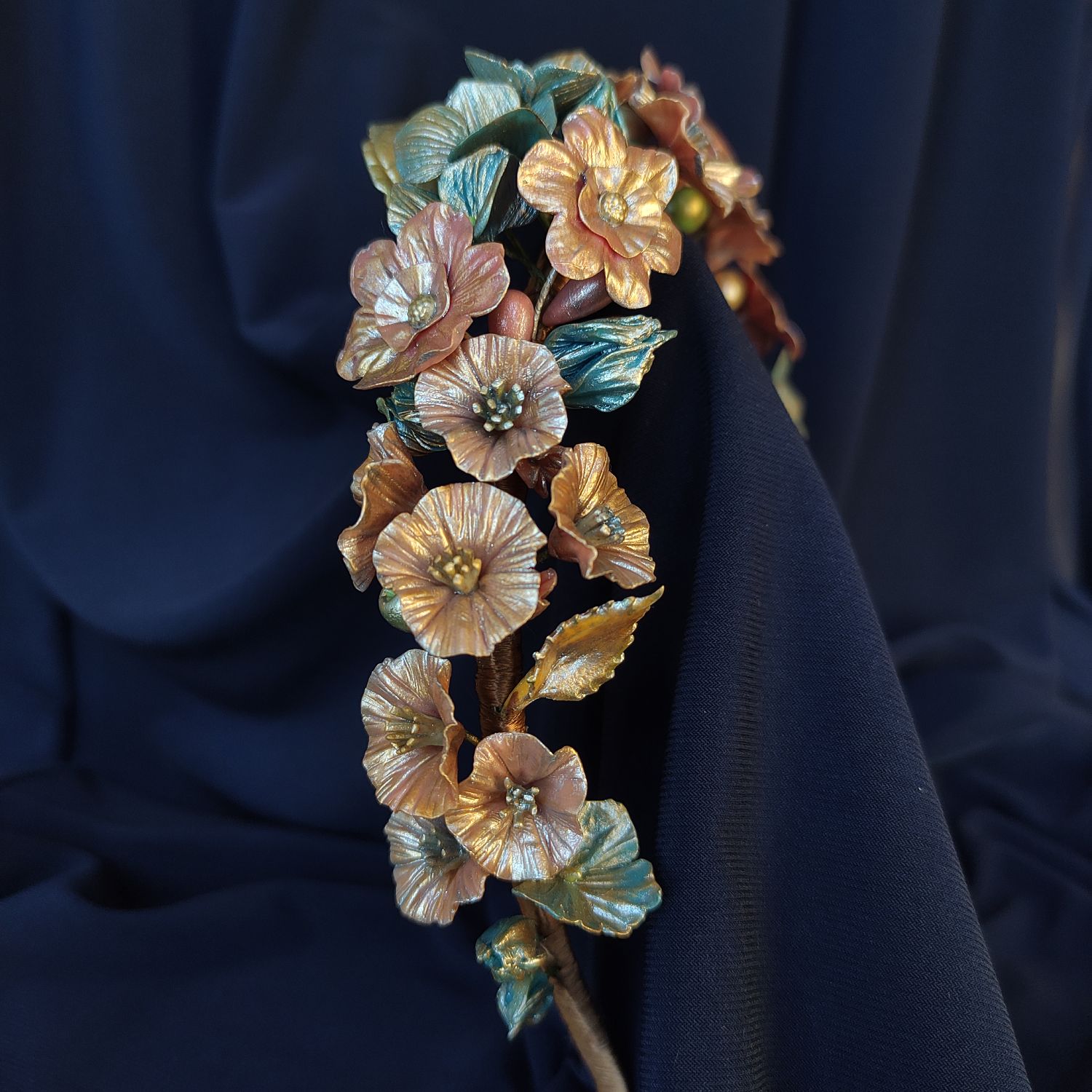 Fantasy flower headband with metallic red and blue blooms complemented by elegant golden leaves.